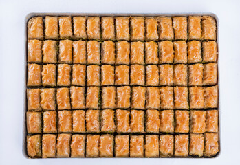 Top view of pistachio baklava on a tray isolated on white background.