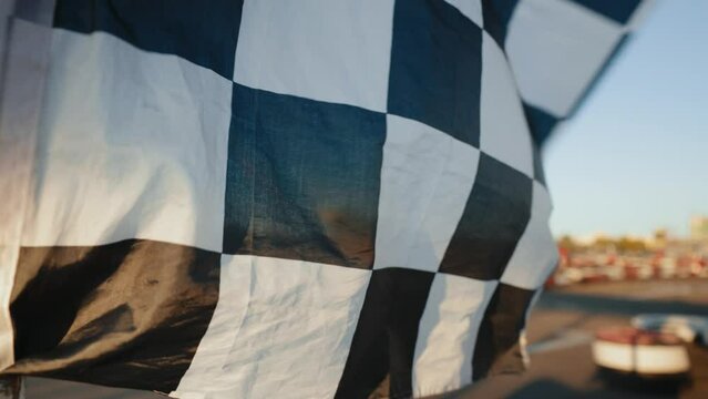 Racing flag waving on open air motor racing track