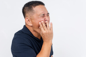 A middle aged Asian man with experiencing excruciating pain, holding his cheek due to a toothache. Potential exposed nerve in the tooth.