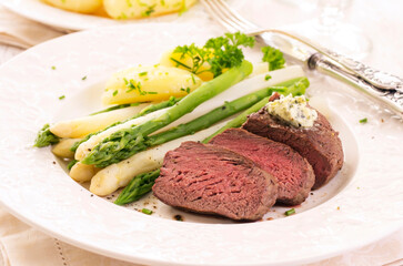 Traditional roasted angus beef steak with white and green asparagus, boild potatoes and sauce...