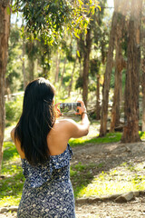 vertical photo latina woman taking a picture of the forest in bolivia - nature concept