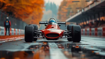 Fototapete A vintage red racing car is positioned on a wet track surrounded by autumn foliage © TheGoldTiger