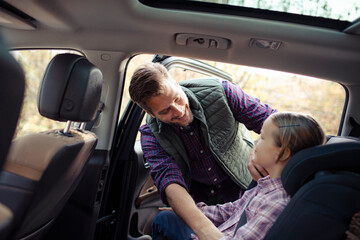 Daughter hugging father on car road trip