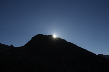 The sun's radiant rays illuminate the mountain peak, casting a bright and beautiful glow upon the landscape.