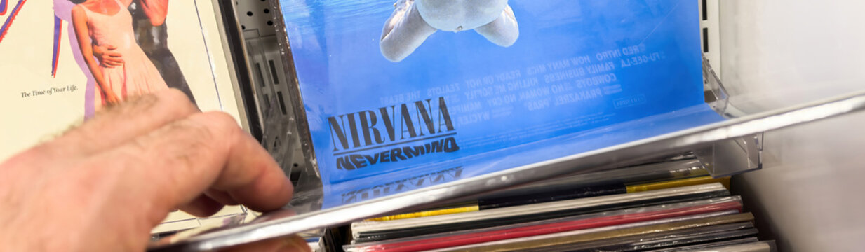 Berlin, Germany - Jan 18, 2024: Customer browsing music albums, iconic baby swimming for dollar album cover.