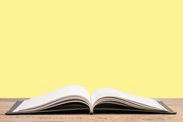 open book. Composition with hardback books, fanned pages on wooden deck table and yellow background. Books stacking. Back to school. Copy Space. Education background.