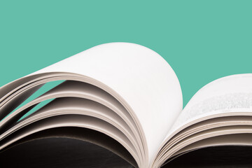 open book. Composition with hardback books, fanned pages on wooden deck table and green background. Books stacking. Back to school. Copy Space. Education background.