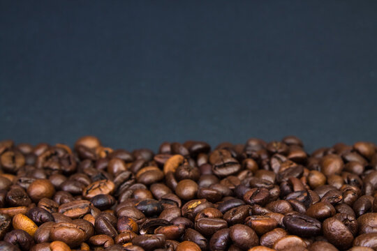 Brown Roasted Coffee Beans Closeup On Dark Background.