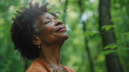 relaxed Mature Black American woman breathing fresh air in a green forest