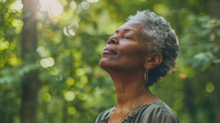relaxed Mature Black American woman breathing fresh air in a green forest