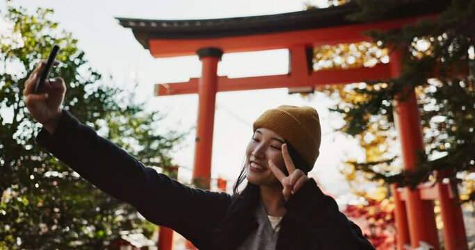Selfie, nature and Japanese woman with peace sign for holiday, vacation and adventure in Japan. Happy, travel and person take picture on smartphone for social media post, memories and online blog