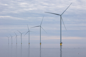 Off shore wind turbines or wind mills at a flat, calm sea, no wind