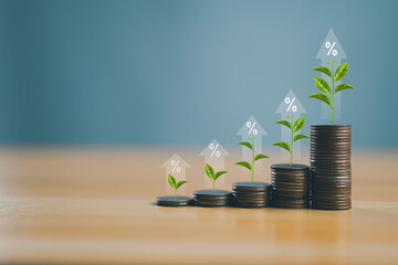 Green leaf plant growing on increasing coin stacking with up arrow for money saving deposit and...