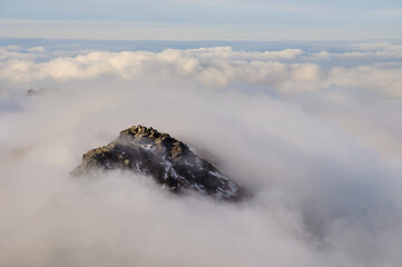 Przetaczające się chmury pomiędzy szczytami górskimi.
