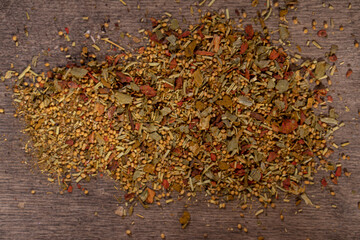 Spicy vegetable spices scattered on a wooden background