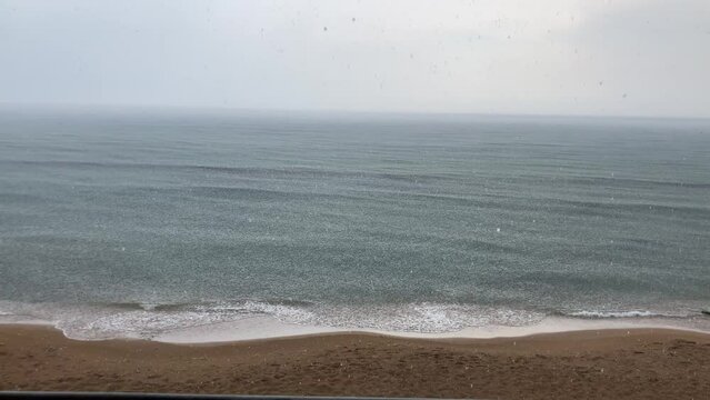 Sea beach thunderstorm with sound, heavy rain on the sea seen from the shore