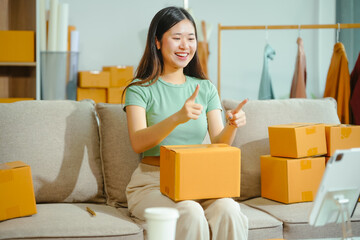 young Asian entrepreneur, the owner of a small clothing store, organizes online live streams...