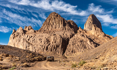 Hoggar landscape in the Sahara desert, Algeria. A view of the mountains and basalt organs that stand around the dirt road that leads to Assekrem. - 738856818