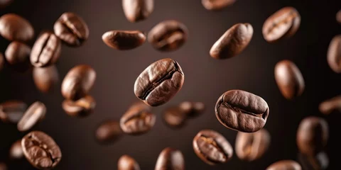 Tuinposter Closeup Brown Roasted Coffee Beans in flight On Dark Background © inthasone