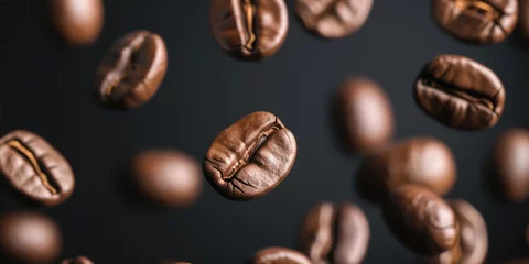  Closeup Roasted Coffee Beans in flight On Dark Background © inthasone