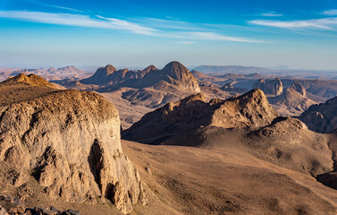 Hoggar landscape in the Sahara desert, Algeria. A view of the mountains and basalt organs that stand around the dirt road that leads to Assekrem. - 738858085