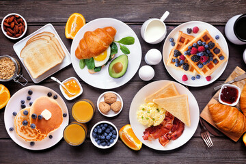 Breakfast or brunch table scene on a dark wood background. Above view. Assortment of sweet and...
