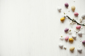 Easter flat lay. Stylish easter chocolate eggs and cherry blossom on rustic white table. Happy...