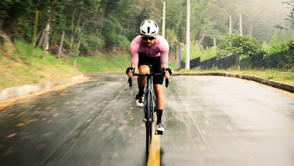 Cyclist man in the middle of the street in motion running at high speed with a lot of motivation. Moving and dynamic background