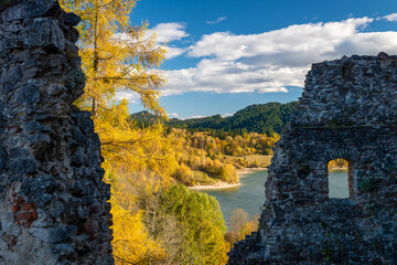 ruiny średniowiecznego zamku nad brzegiem górskiego jeziora w jesienny słoneczny dzień