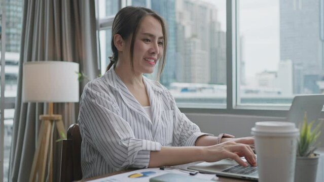 Young Asian businesswoman work at home and virtual video conference meeting with colleagues business people,online working,remote work,video call,remote working discuss concersation strategy business