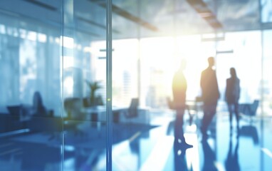 The photo captures a group of diverse individuals in an office setting, their features blurred but hinting at a busy and active environment. People appear to be engaged in various tasks, possibly coll