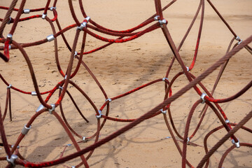 
Red rope sections fastened with a metal clamp and a brown sand background