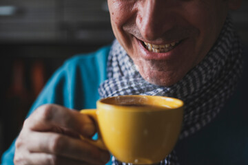 Adult mature man drinking tea and looking outside the windows at home