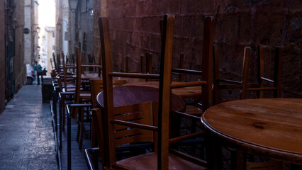 Closed summer cafe at night in the city, the chairs are turned over on the tables