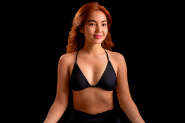 Fototapeta premium Portrait of a beautiful woman in a black bra on a black background