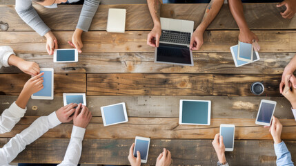 overhead view of a wooden table with six individuals seated around it, each holding a tablet with a blank screen.