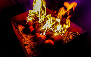 Fire and flames on barbecue in the dark Maldives.
