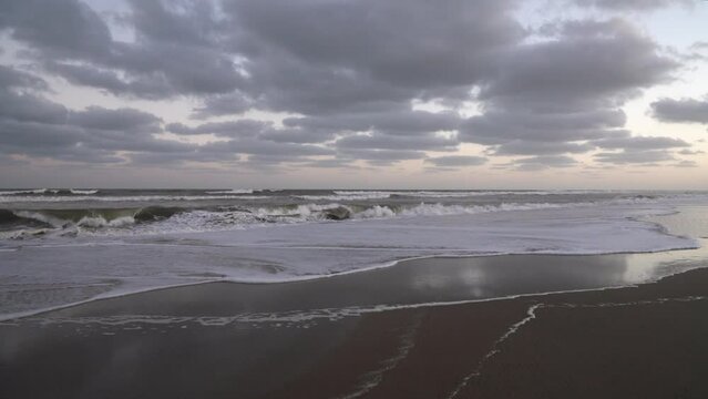 Vacations. Panorama view of the empty beach and ocean under a sunset sky. Beautiful sky reflection in the sea waves.