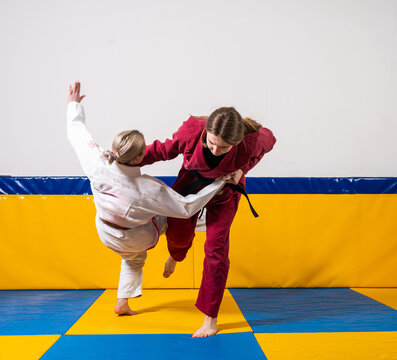 Young girls and boys practice Brazilian jiu jitsu in the gym