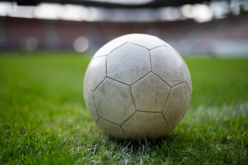 White soccer ball lying on the grass at stadium