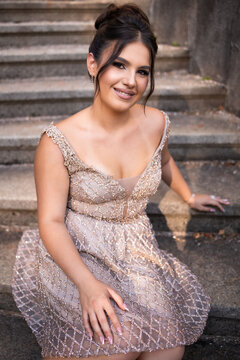Close up portrait of a teen brunette girl in a golden dress. Ready for prom