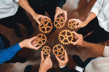 Business team joining cogwheel in circular together symbolize successful group of business partnership and strong collective unity teamwork in community workplace with productive efficiency. Prudent