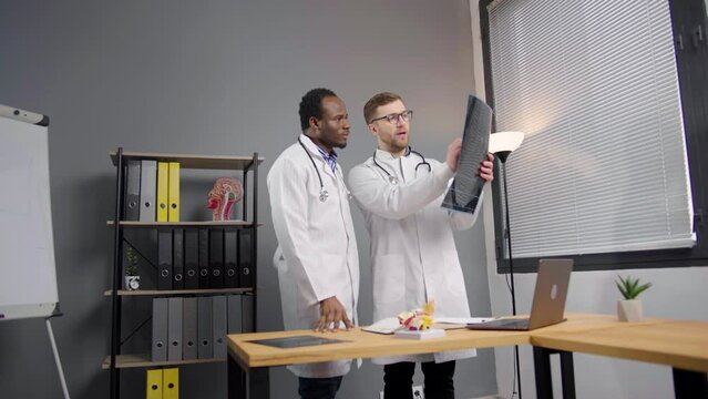 Two doctors in Lab Coats Analyzing X-ray image of patient