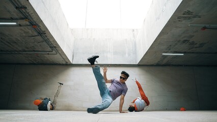 Group of stylish hipster perform dancing together in building. Happy break dancer enjoy moving to hip hop music with freestyle dance surrounded by street dancer team. Outdoor sport 2024. Sprightly.