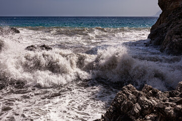 Large waves breaking over rocks - 738922030