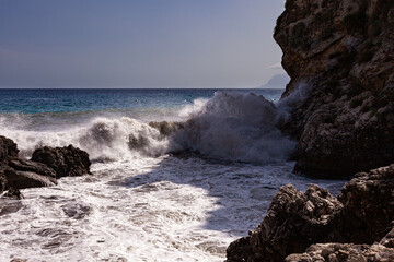 Large waves breaking over rocks - 738922470