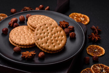 Round dotted snack snack cookies with cream on a dark concrete background