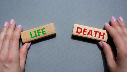Life or Death symbol. Concept word Life or Death on wooden blocks. Businessman hand. Beautiful grey...