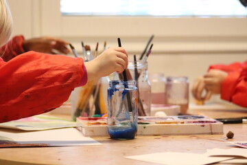 children with brushes. Children paint with paint.