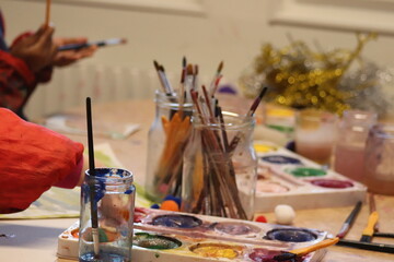 children with brushes. Children paint with paint.